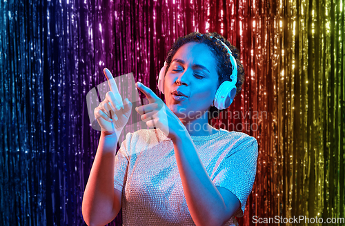 Image of woman in headphones listening to music and dancing