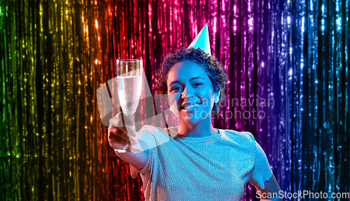 Image of african woman in party cap with glass of champagne