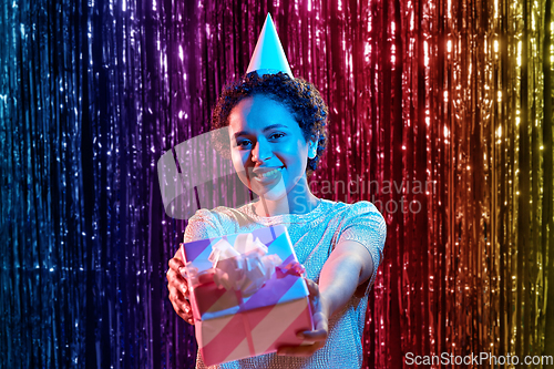 Image of african woman in birthday party cap with gift box