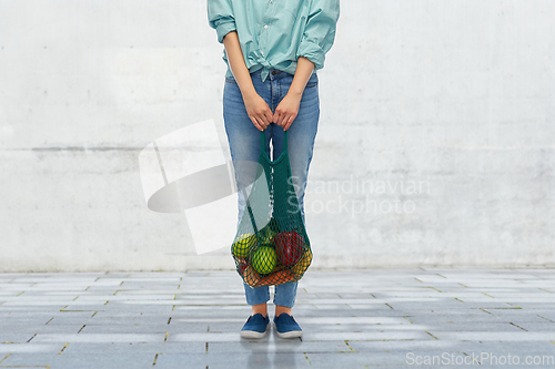 Image of woman with food in reusable string bag