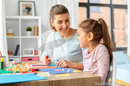 Image of daughter with mother making applique at home