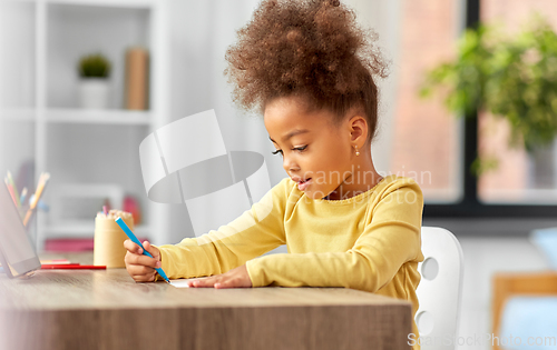 Image of little girl with felt pen drawing picture at home