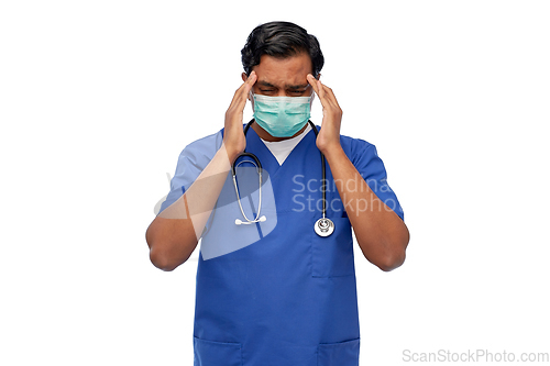 Image of stressed indian doctor in mask having headache