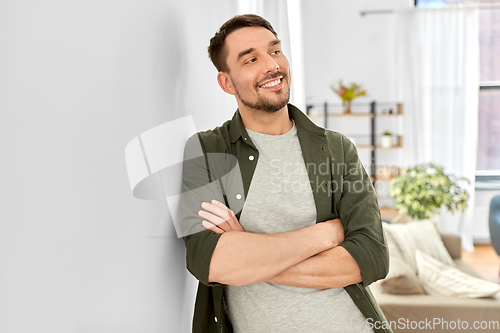 Image of happy smiling man with crossed arms at home