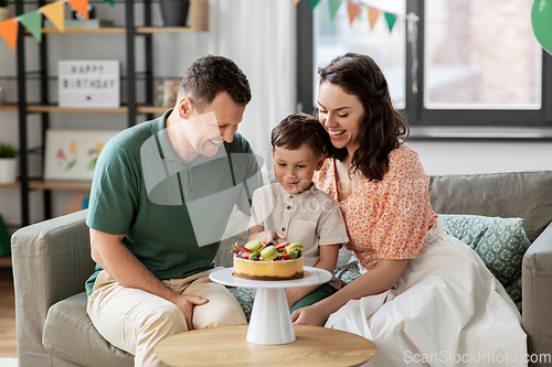 Image of happy family with birthday cake at home