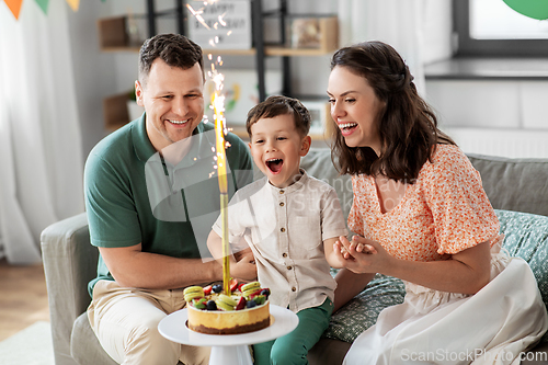 Image of happy family with birthday cake at home