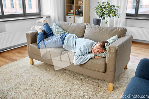 Image of young man sleeping on sofa at home