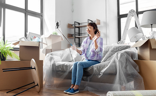 Image of woman having video call and moving into new home