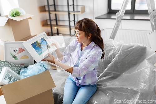 Image of happy woman unpacking boxes and moving to new home