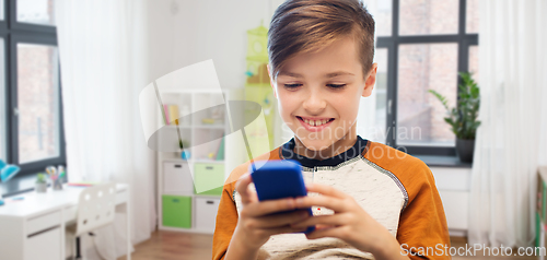 Image of boy with smartphone texting or playing at home