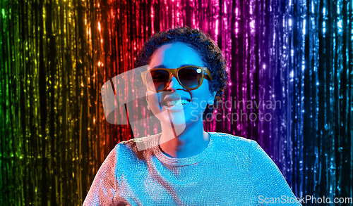 Image of african woman in sunglasses over neon lights