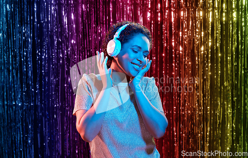 Image of woman in headphones listening to music at party