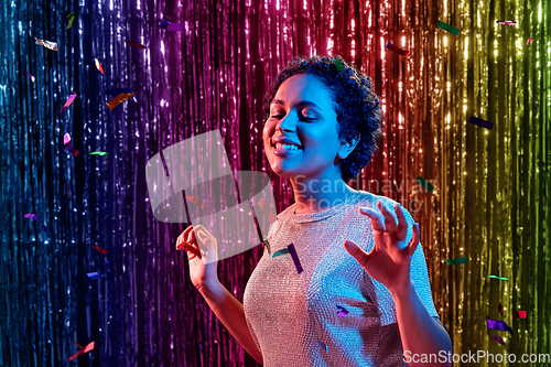 Image of african woman under confetti at nightclub party