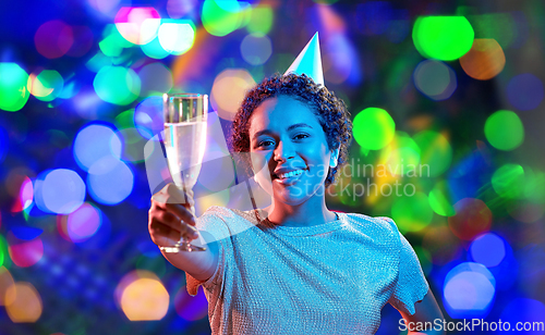 Image of african woman in party cap with glass of champagne
