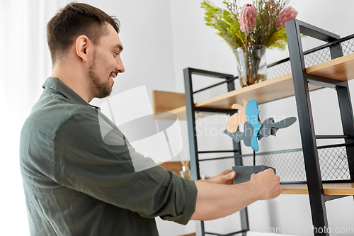 Image of man decorating home with art in frame