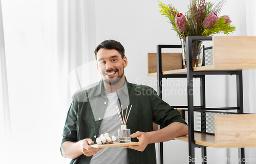 Image of man placing aroma reed diffuser to shelf home