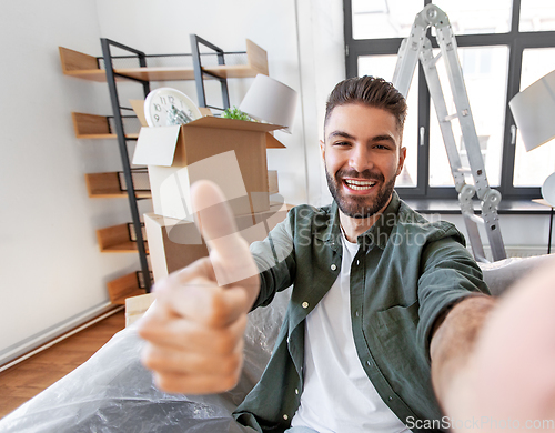 Image of man having video call and moving into new home