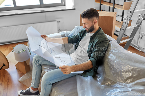 Image of happy man with blueprint moving to new home