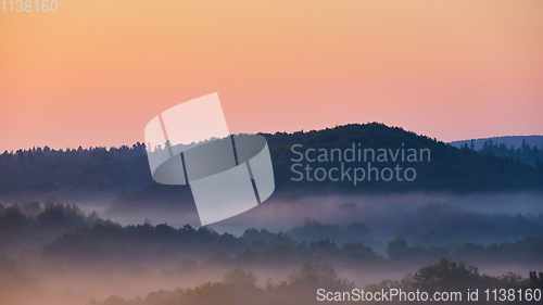 Image of Misty morning of hilly area with ray of light.