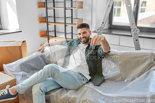 Image of man with house keys and boxes moving to new home