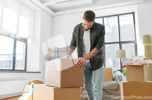 Image of happy man with boxes moving to new home