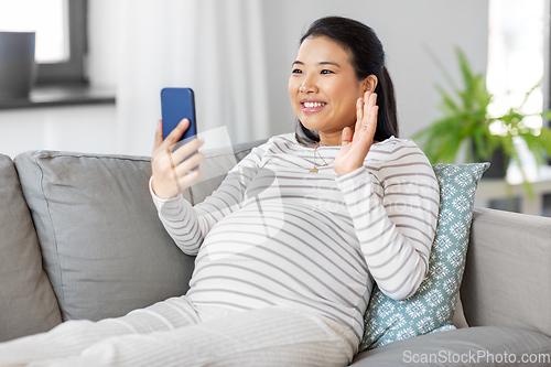 Image of happy pregnant woman having video call on phone