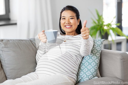 Image of happy pregnant woman drinking tea at home