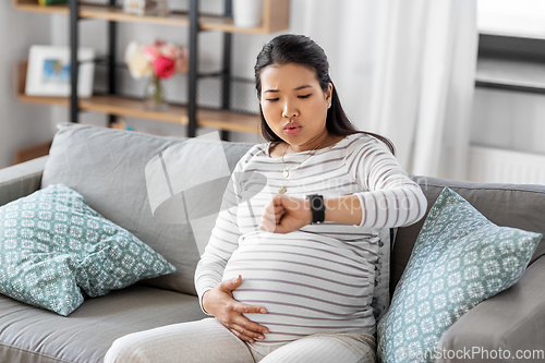 Image of pregnant woman having labor contractions at home