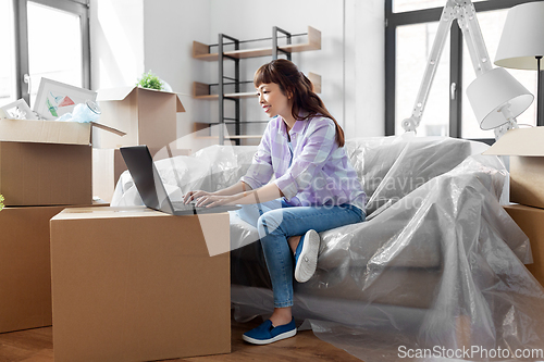 Image of woman with laptop moving into new home