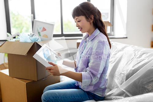 Image of happy woman unpacking boxes and moving to new home