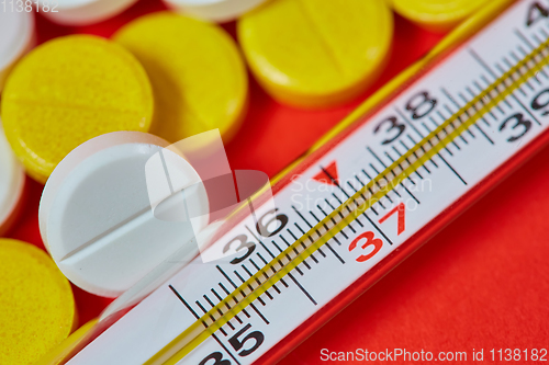 Image of Mercury thermometer and medical pills on background