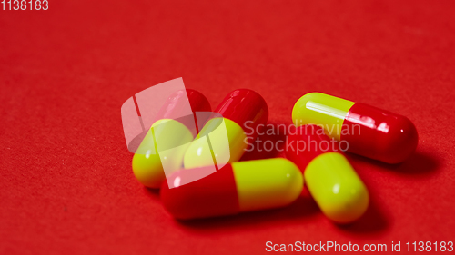 Image of Pills spilling out of pill bottle on red. Top view with copy space. 