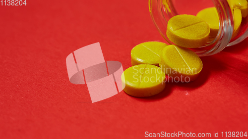 Image of Pills spilling out of pill bottle on red. Top view with copy space. 