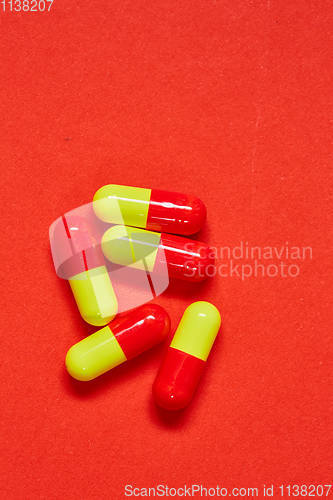 Image of Pills spilling out of pill bottle on red. Top view with copy space. 