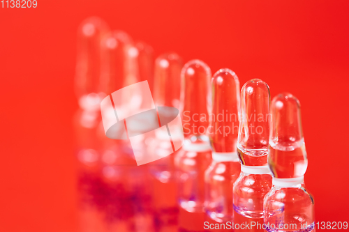 Image of Medical ampules on a red background, selective focus. 