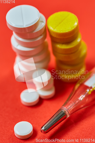 Image of Mercury thermometer and medical pills on background