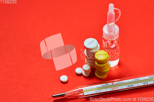 Image of Mercury thermometer and medical pills on background