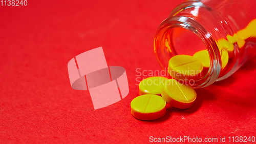 Image of Pills spilling out of pill bottle on red. Top view with copy space. 