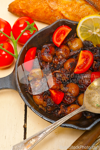 Image of Baby cuttle fish roasted on iron skillet