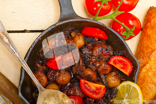 Image of Baby cuttle fish roasted on iron skillet