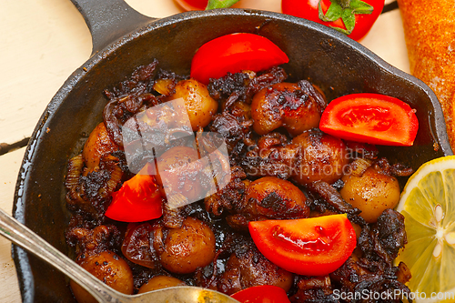 Image of Baby cuttle fish roasted on iron skillet