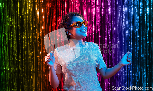 Image of african american woman dancing over neon lights