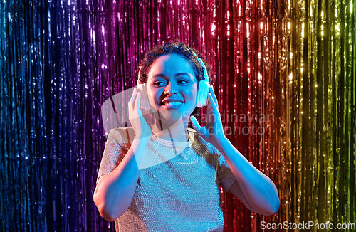 Image of woman in headphones listening to music at party