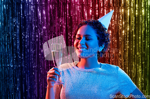 Image of african woman in party cap with glass of champagne