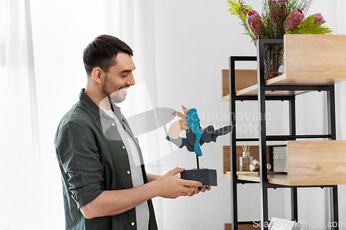 Image of man decorating home with art in frame