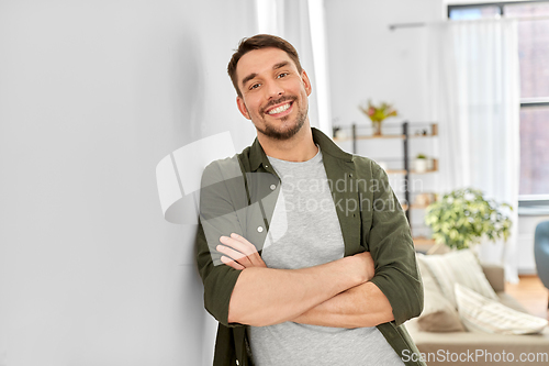 Image of happy smiling man with crossed arms at home