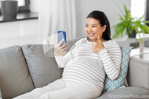 Image of happy pregnant woman having video call on phone