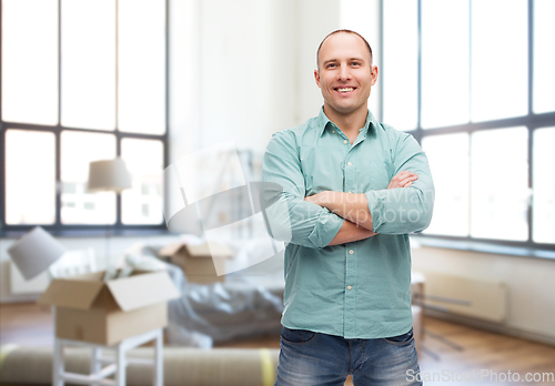 Image of smiling man with crossed arms at new home