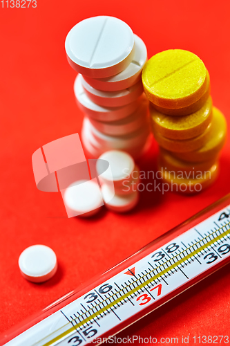 Image of Mercury thermometer and medical pills on background