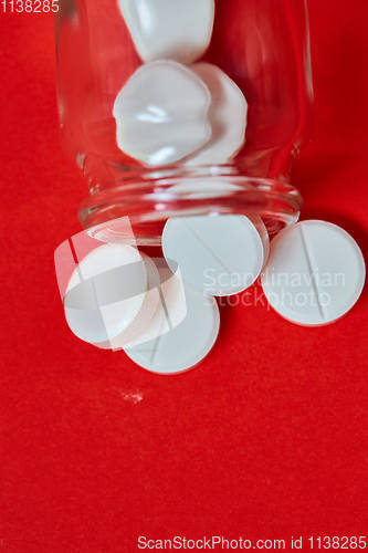 Image of Pills spilling out of pill bottle on red. Top view with copy space. 